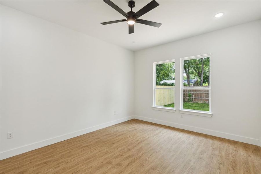 Unfurnished room with light hardwood / wood-style floors and ceiling fan