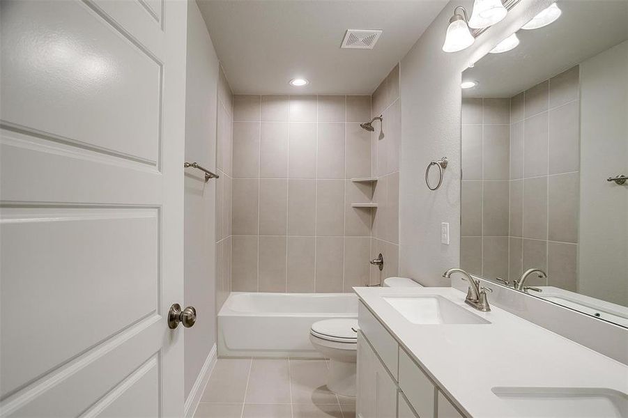 Full bath with double vanity, bathtub / shower combination, light tile patterned flooring, and recessed lighting Full bath with double vanity, bathtub / shower combination, light tile patterned flooring, and recessed lighting