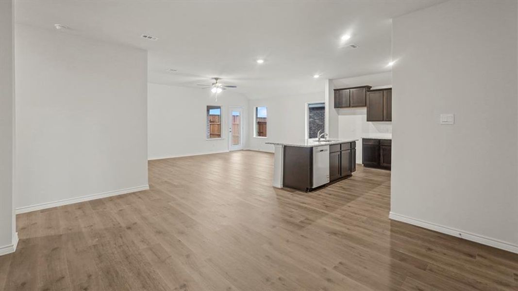 Open-concept living space with wood-finish flooring, white baseboards, and neutral wall tones