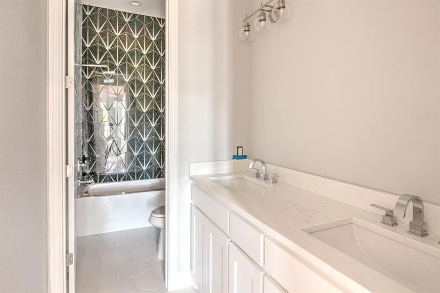 Full bathroom with toilet, tiled shower / bath, vanity, and tile patterned flooring