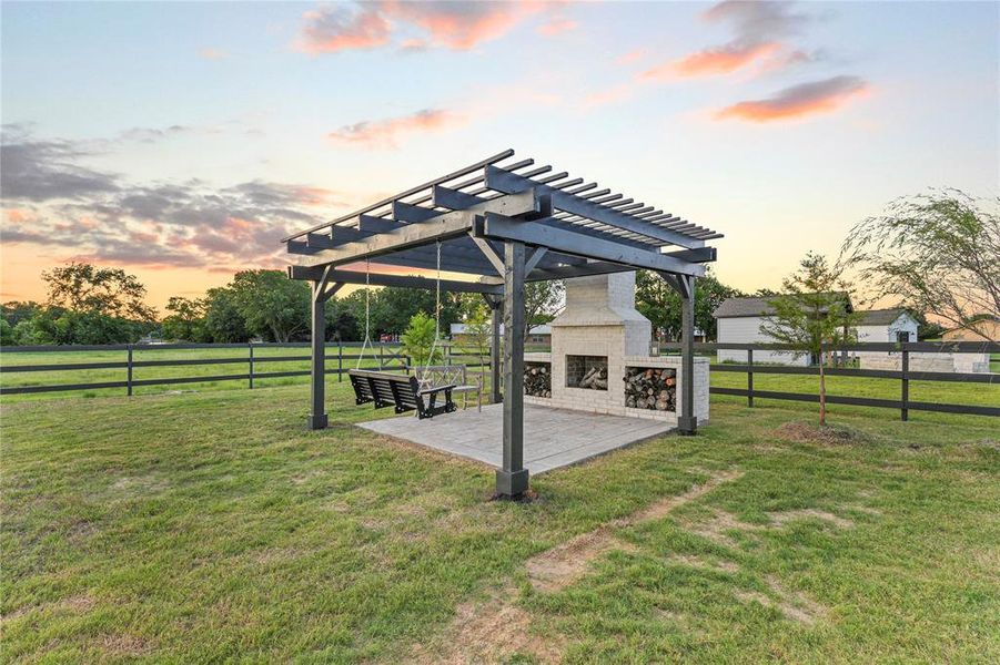 View of yard with an outdoor fireplace, a pergola, and a patio View of yard with an outdoor fireplace, a pergola, and a patio