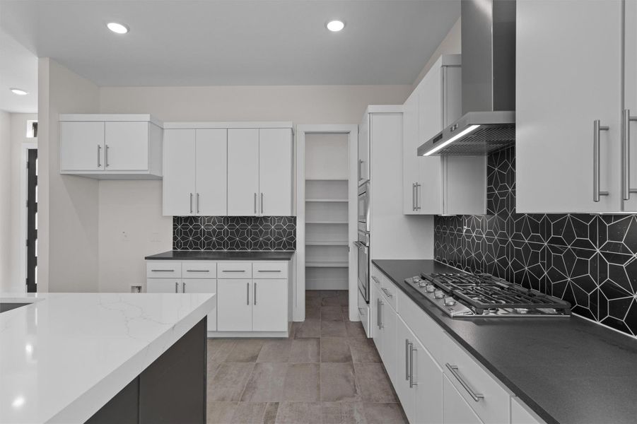Kitchen featuring backsplash, wall chimney exhaust hood, white cabinetry, recessed lighting, and appliances with stainless steel finishes Kitchen featuring backsplash, wall chimney exhaust hood, white cabinetry, recessed lighting, and appliances with stainless steel finishes
