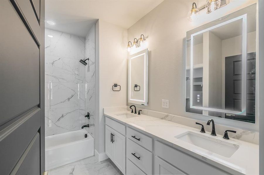 Bathroom featuring vanity and tiled shower / bath