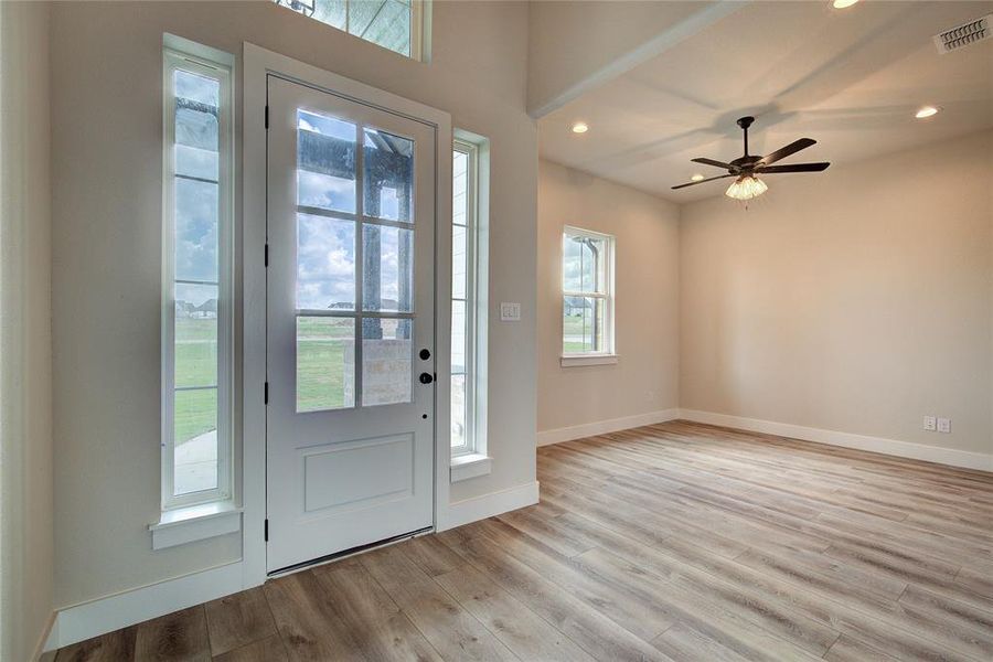 Foyer with ceiling fan and light wood-type flooring