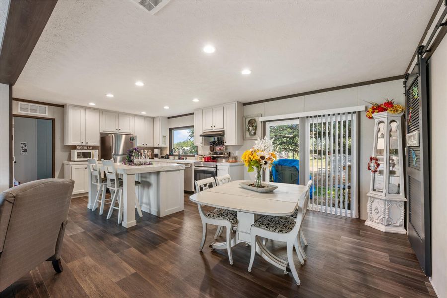 Dining room with recessed lighting, dark wood-style flooring, and crown molding