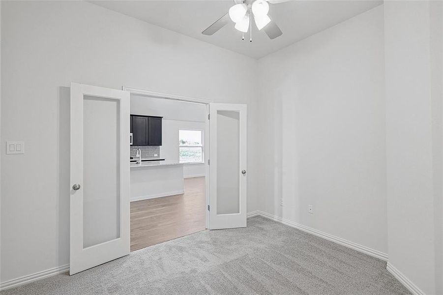 Unfurnished bedroom featuring carpet flooring, ceiling fan, and french doors