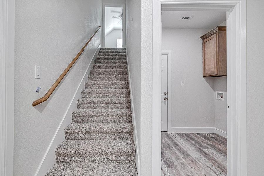 Stairway with light hardwood / wood-style flooring