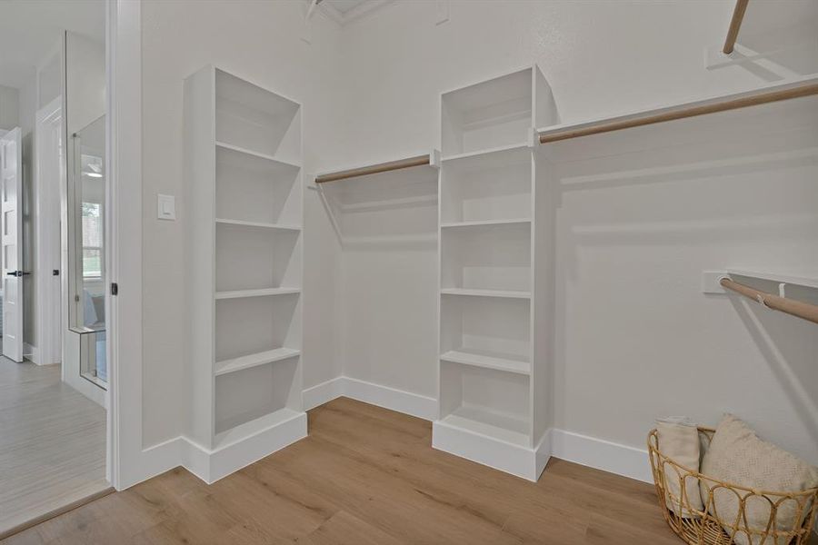 Walk in closet featuring wood finished floors Walk in closet featuring wood finished floors