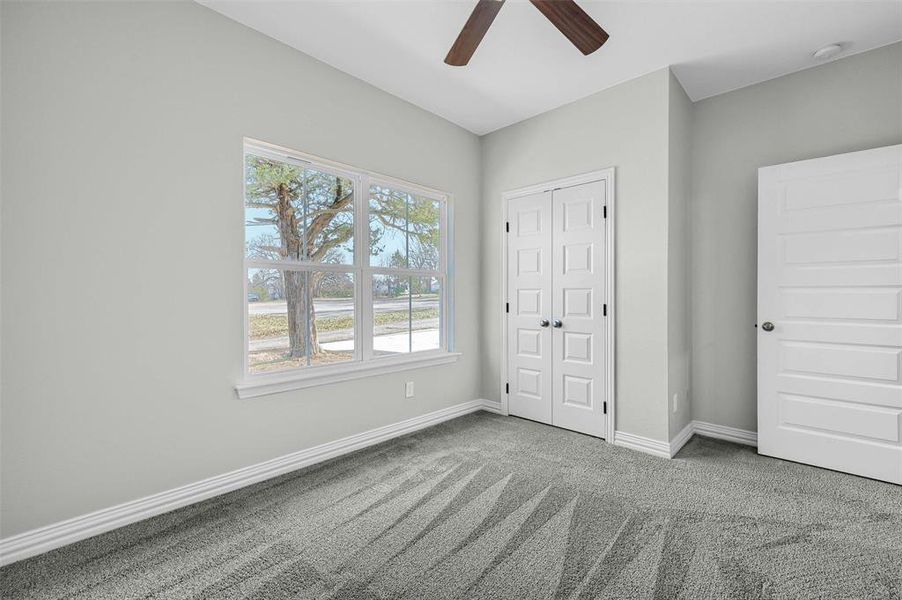 Unfurnished bedroom featuring carpet, a closet, and ceiling fan