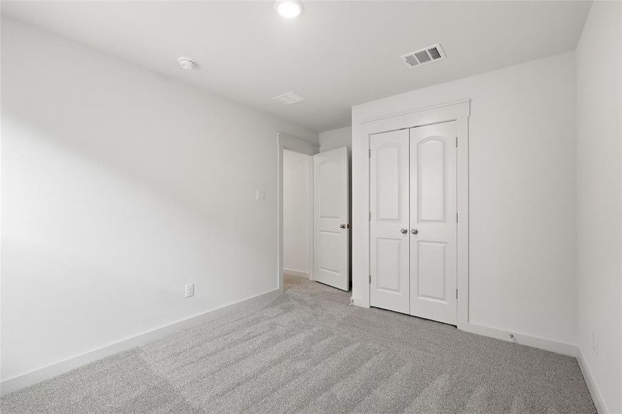 Unfurnished bedroom with carpet flooring and a closet Unfurnished bedroom with carpet flooring and a closet