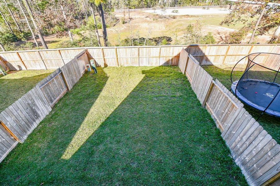 This sprawling fenced yard is ready for barefoot fun with plenty of grassy lawn for outdoor play.