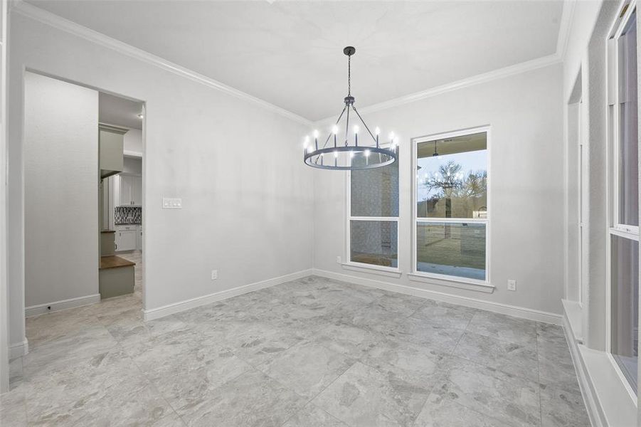 Unfurnished dining area with ornamental molding and a chandelier Unfurnished dining area with ornamental molding and a chandelier