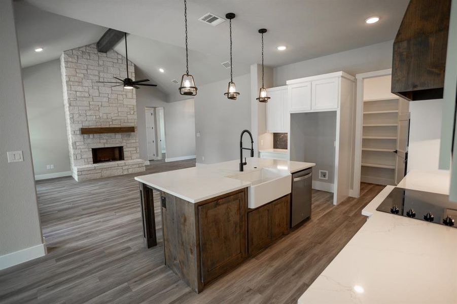 Kitchen featuring white cabinetry, an island with sink, dark wood finished floors, beam ceiling, and pendant lighting Kitchen featuring white cabinetry, an island with sink, dark wood finished floors, beam ceiling, and pendant lighting