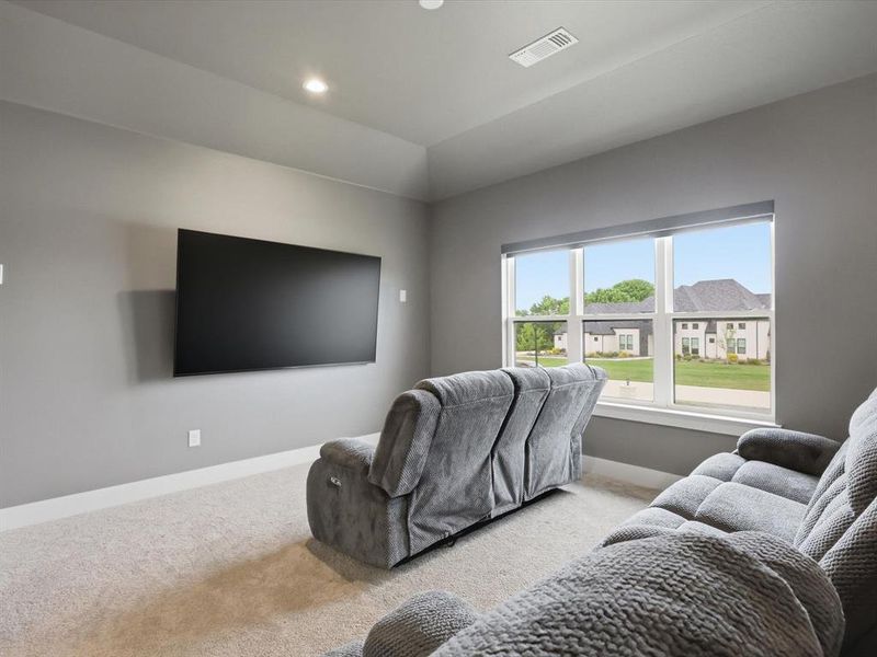 Media room featuring a tray ceiling, recessed lighting, and light-toned carpet flooring