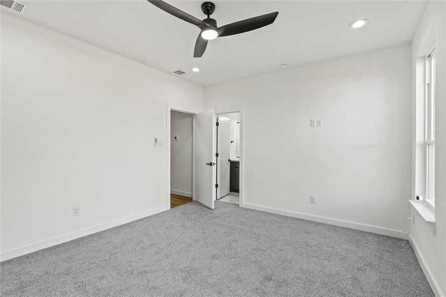 Carpeted empty room featuring ceiling fan