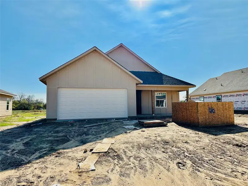 View of front of home featuring a garage, board and batten siding, driveway, and roof with shingles