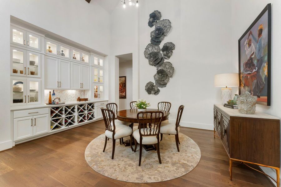 Built-in cabinetry and display areas create a beautiful transition between dining and entertaining spaces. Wine storage and illuminated shelving add a refined, functional layer to the home’s main living area.