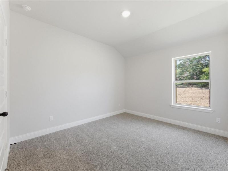 Room featuring neutral gray carpeting, light gray wall paint, and a single window with white trim Room featuring neutral gray carpeting, light gray wall paint, and a single window with white trim