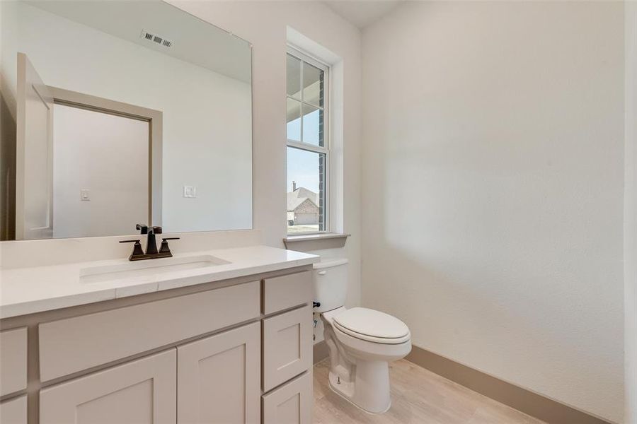 Bathroom featuring vanity, hardwood / wood-style floors, and toilet