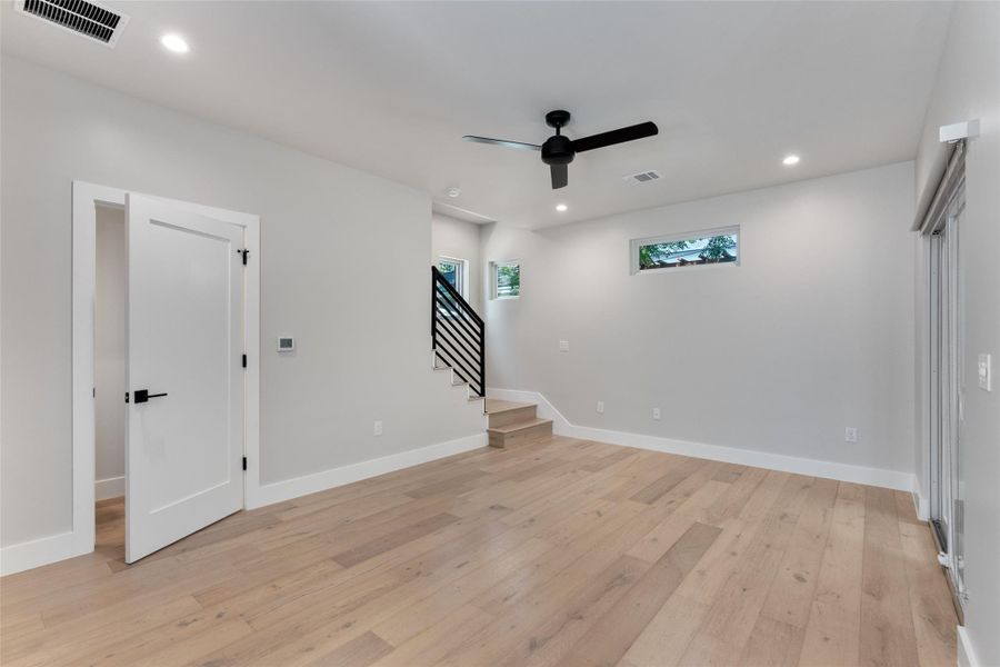 Living area spacious and bright. Featuring light hardwood flooring, recessed lighting, and a contemporary ceiling fan. Living area spacious and bright. Featuring light hardwood flooring, recessed lighting, and a contemporary ceiling fan.