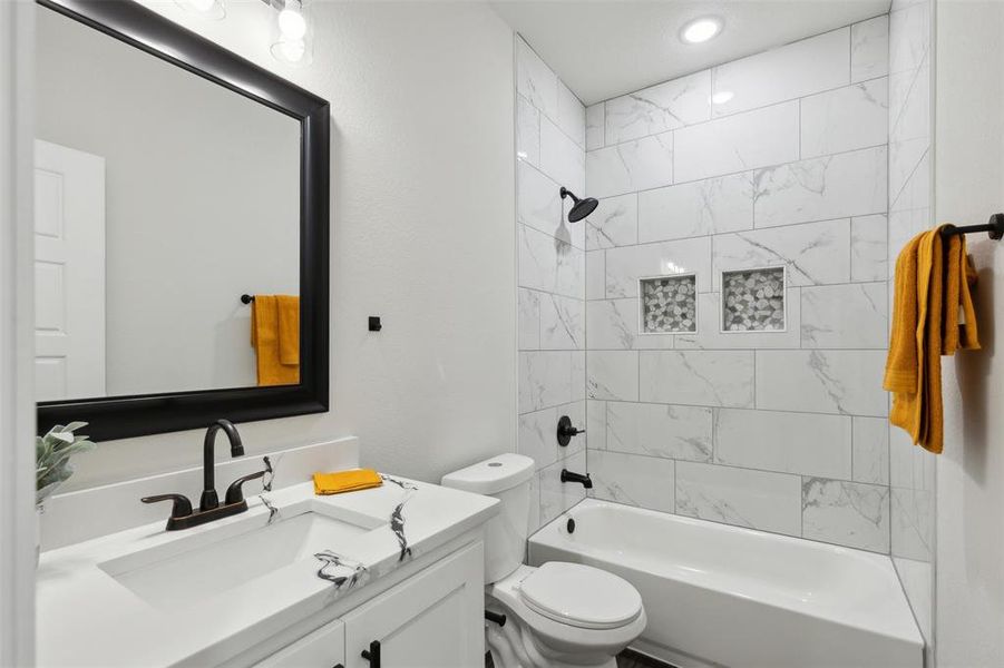 Full bathroom with vanity, toilet, and tiled shower / bath