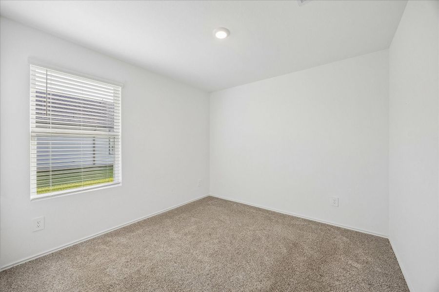 Secondary bedroom features neutral carpet and wall paint.