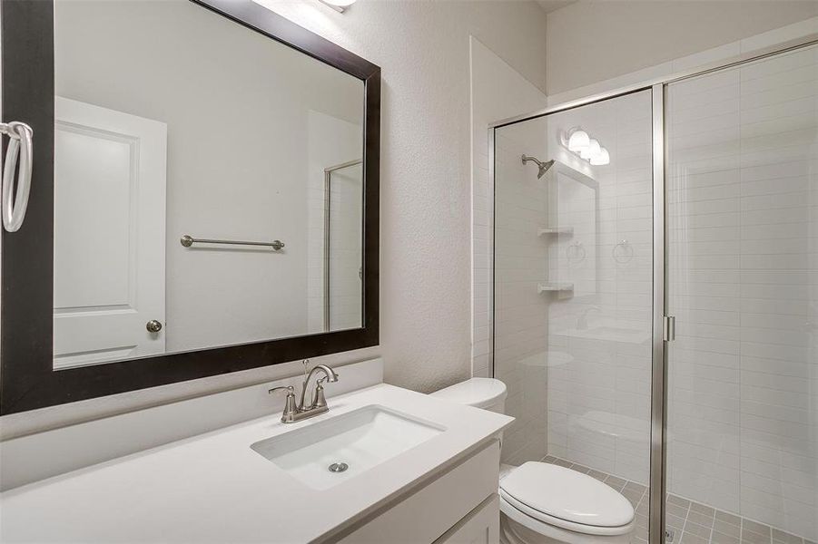 Bathroom featuring vanity, toilet, and walk in shower