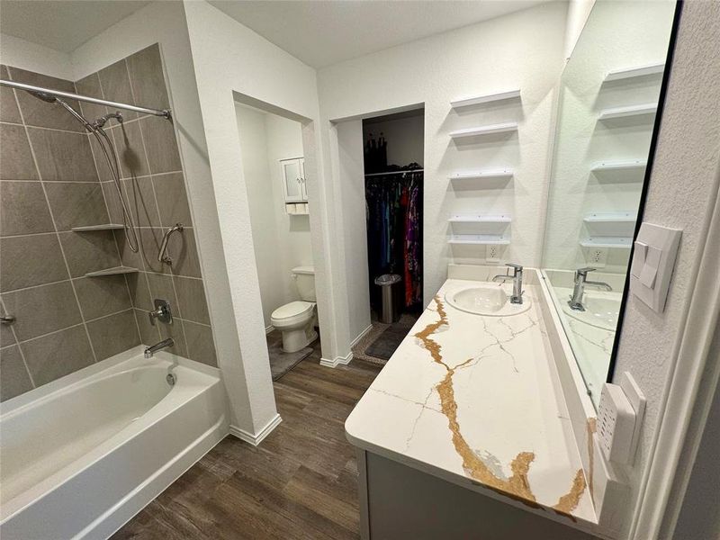 Large vanity counterop with built in shelving provides generous storage and space