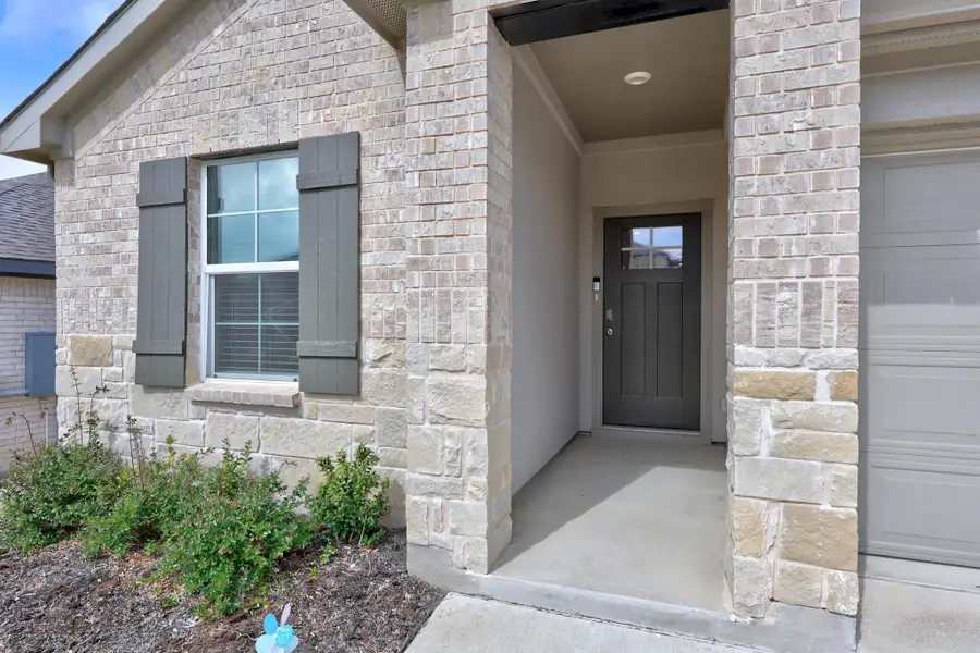 Entrance to property with stone siding and a garage