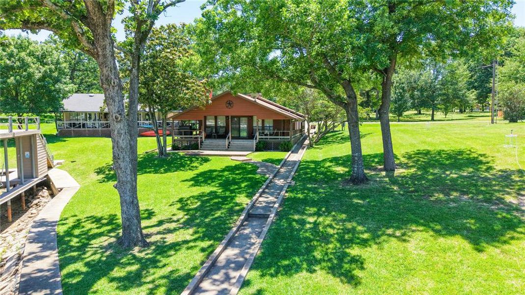Charming single-story lake home with wraparound covered porch and beautifully landscaped lots, perfectly situated on 120 feet of waterfront.