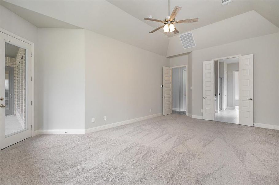 Unfurnished bedroom featuring access to exterior, ceiling fan, light colored carpet, and vaulted ceiling