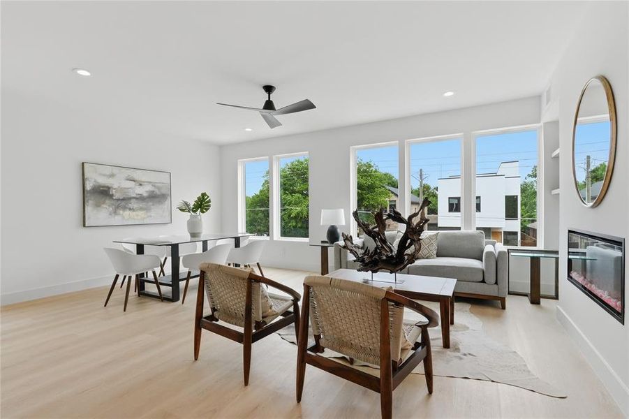 Open-concept living space featuring wood-finish flooring, recessed lighting, and a contemporary ceiling fan Open-concept living space featuring wood-finish flooring, recessed lighting, and a contemporary ceiling fan