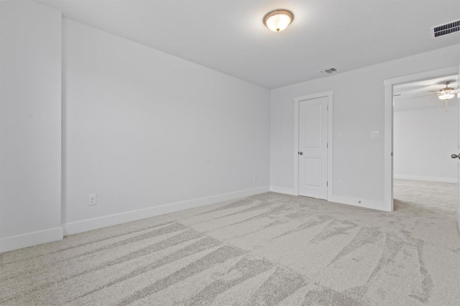 Carpeted spare room featuring ceiling fan