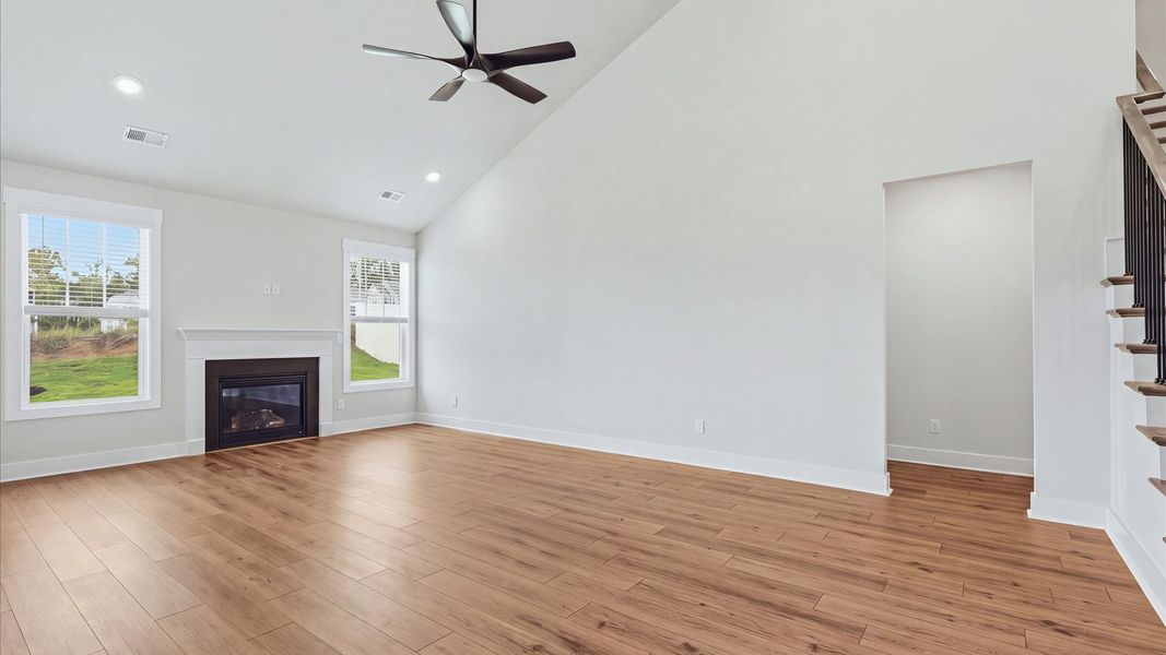 Eye-catching two-story family room with elegant trim, oversized windows, and elevated design at the Fox Hollow community