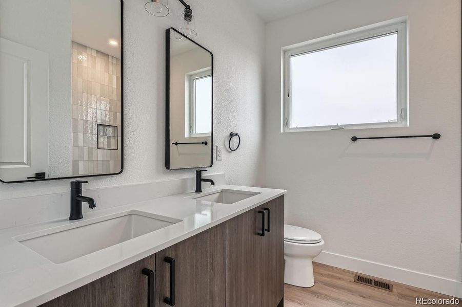 Large full bathroom on 3rd level with double vanity, quartz countertops, tub, and shower.