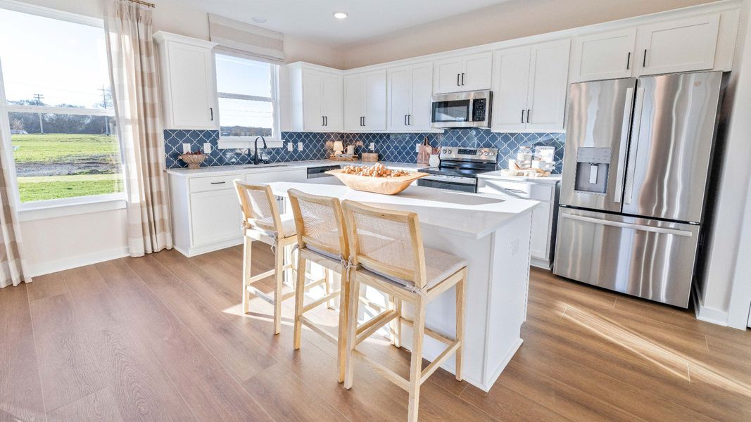 Kitchen with tile backsplash, quartz countertops, and hard surface flooring