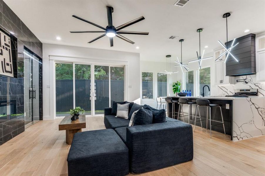 Living room featuring ceiling fan, light wood-style floors, and recessed lighting Living room featuring ceiling fan, light wood-style floors, and recessed lighting