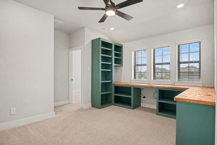 Loft area with custom built-ins, window blinds and ceiling fan. Loft area with custom built-ins, window blinds and ceiling fan.