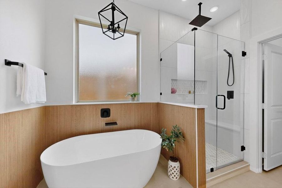 Full bath with a stall shower, wainscoting, a freestanding tub, and wood walls