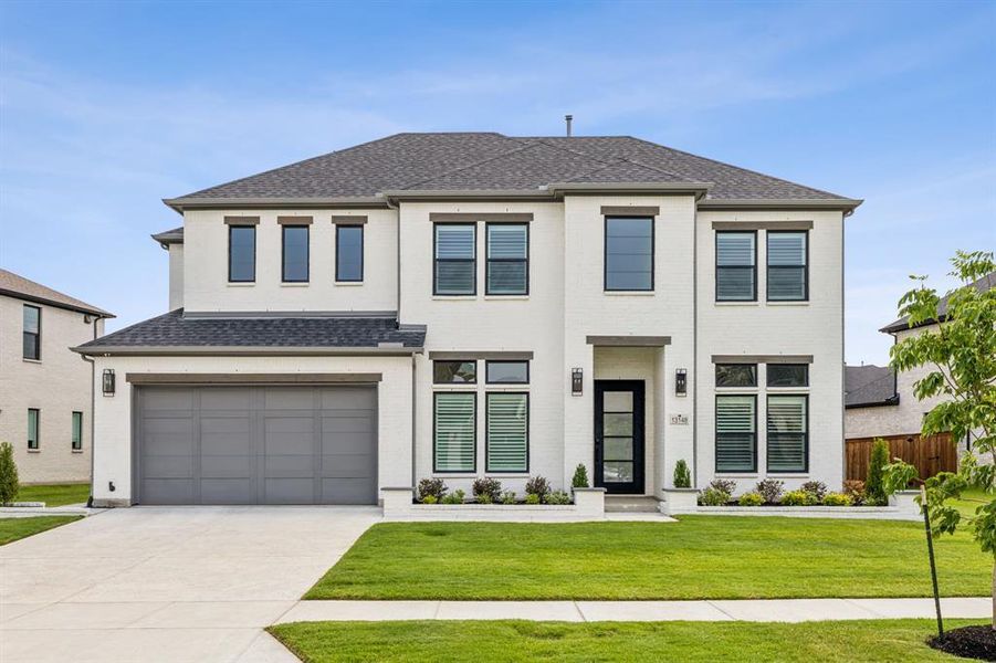 View of front of house with a garage and a front lawn