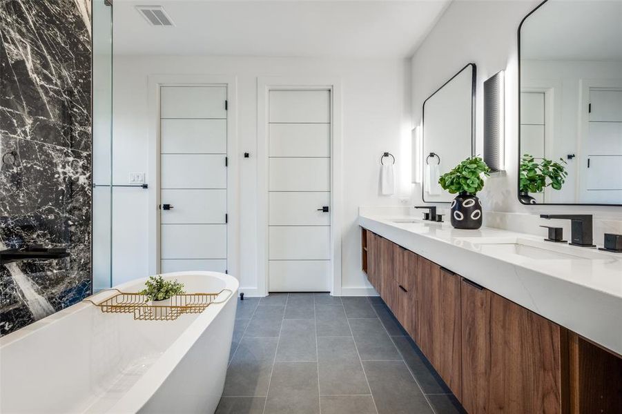 Full bathroom featuring double vanity, a soaking tub, and tile patterned floors Full bathroom featuring double vanity, a soaking tub, and tile patterned floors