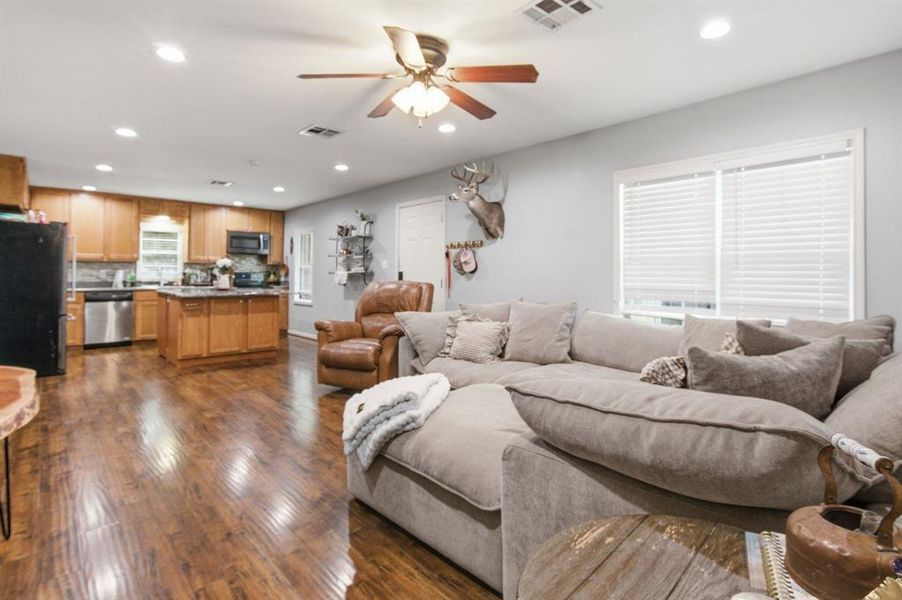 Open-concept living area featuring wood-finish flooring, recessed lighting, and a ceiling fan