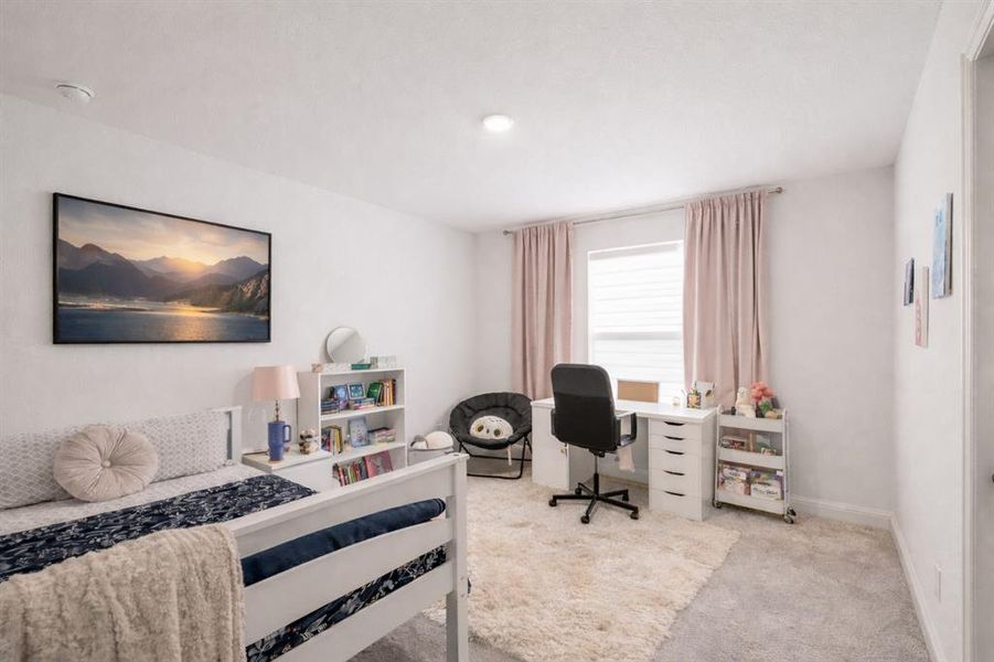 Bedroom featuring an office area and light colored carpet