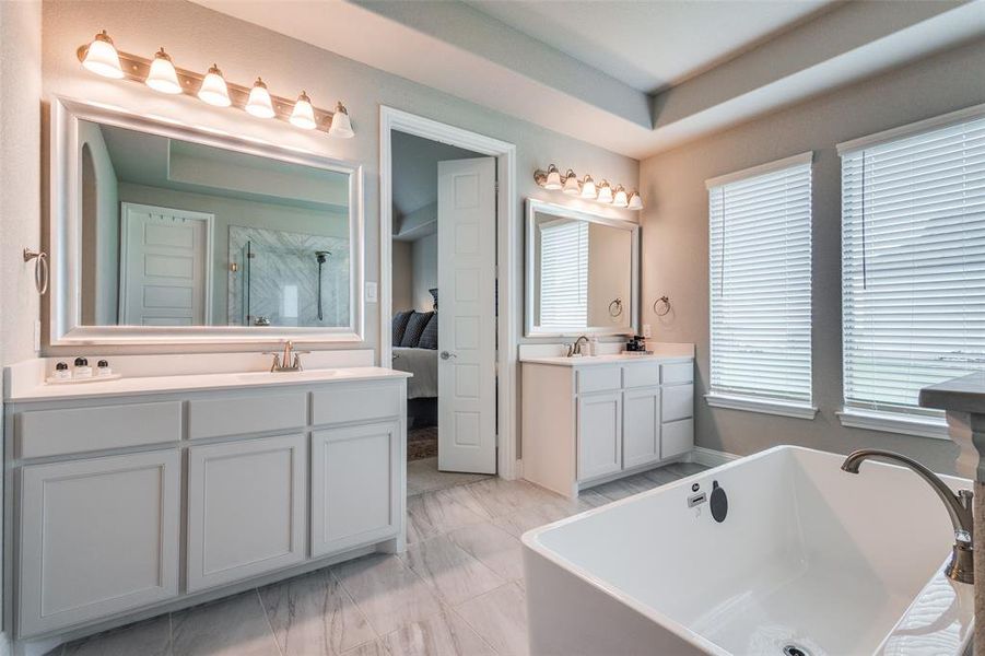 Separate sinks offer convenience and personal space in the master bath, combining functionality with elegant design.