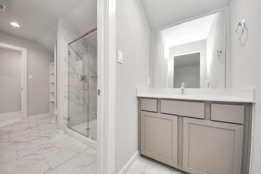 Experience convenience in the secondary bathroom, designed for Jack and Jill arrangements, now with a separate vanity area. This well-appointed space showcases stylish tile flooring, a bath/shower combo with an elegant tile surround, and light-stained wood cabinets. The beautiful light countertop adds a touch of sophistication, combining functionality and aesthetics seamlessly. Sample photo of completed home with similar floor plan. Actual colors and selections may vary. Experience convenience in the secondary bathroom, designed for Jack and Jill arrangements, now with a separate vanity area. This well-appointed space showcases stylish tile flooring, a bath/shower combo with an elegant tile surround, and light-stained wood cabinets. The beautiful light countertop adds a touch of sophistication, combining functionality and aesthetics seamlessly. Sample photo of completed home with similar floor plan. Actual colors and selections may vary.