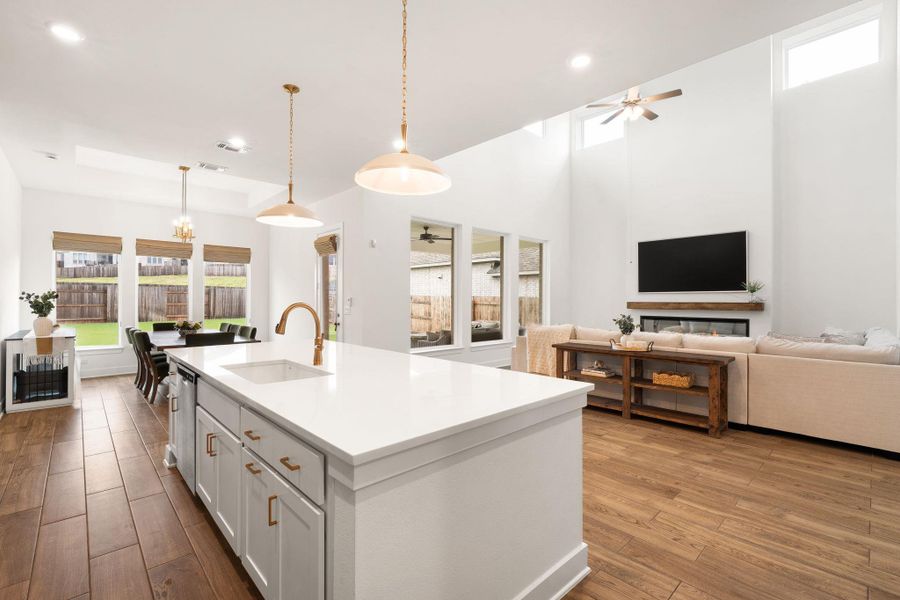 An open concept living space featuring a central kitchen island and soaring ceilings.