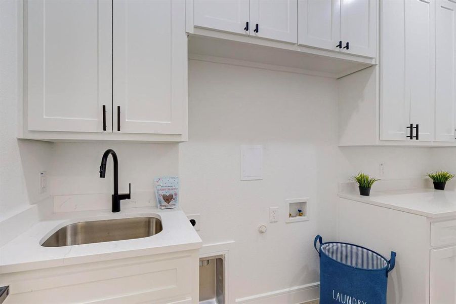 Washroom featuring cabinets, hookup for a washing machine, electric dryer hookup, and sink