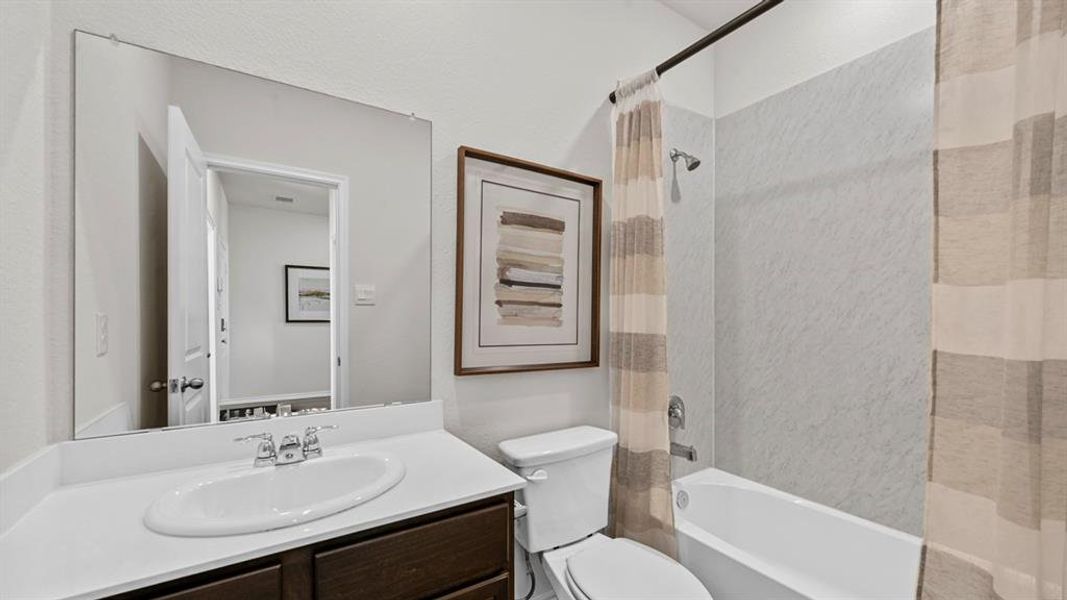 Bathroom with a dark wood vanity, white countertop, and a full-width mirror Bathroom with a dark wood vanity, white countertop, and a full-width mirror