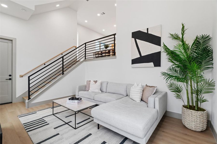 Enjoy a bright, modern living space with durable SPC flooring and a stunning visual connection to the dining area above—bringing style and function together across split levels.