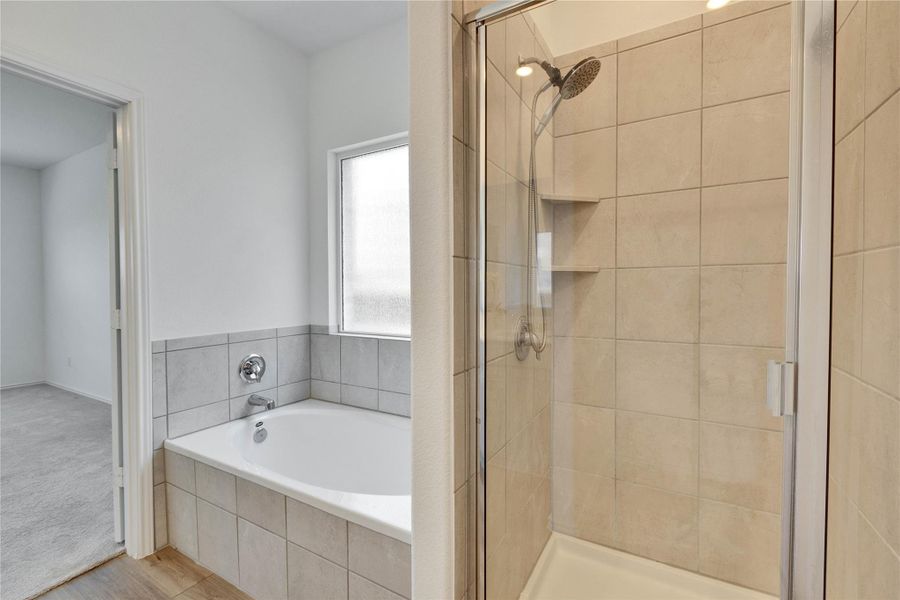 Full bath in primary with a glass stall shower and bathtub. Full bath in primary with a glass stall shower and bathtub.